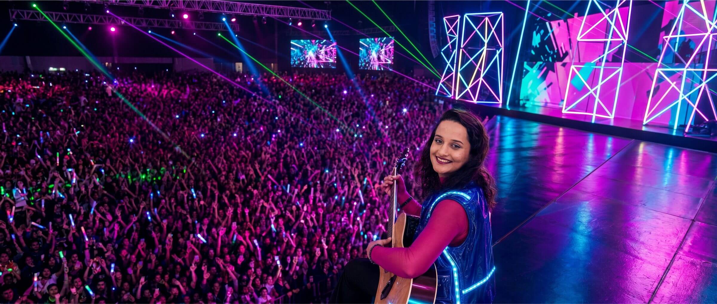 Gauri Tidke performing live on stage in front of a massive concert crowd